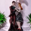 A romantic couple holding sitting on heart shape bench holding umbrella made up of polyresin. A beautiful statue for gifting and showpiece.