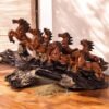 Sculpture of seven brown horses running on a rock made up of polyresin