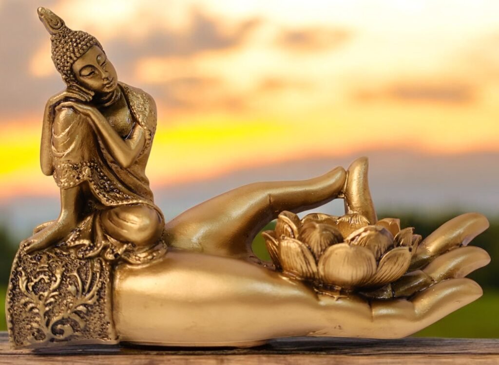 Golden scripture depicting Gautam buddha resting on the wrist of a hand making dhyaan mudra with thumb and fingers moreover a lotus shape stand placed on the palm.